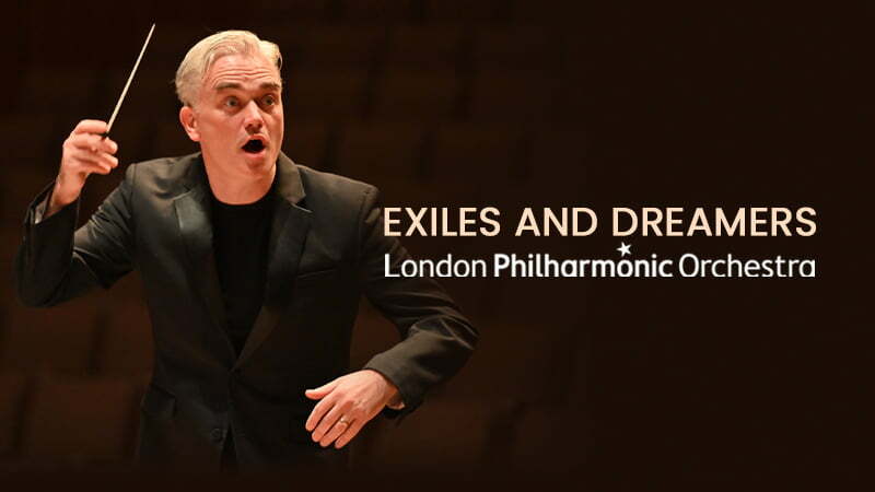 Conductor Edward Gardner holds his baton. Leads to video of the London Philharmonic Orchestra's Exiles and Dreamers Concert.