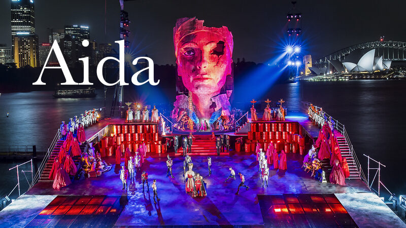 An outdoor set for the opera Aida featuring a large Egyptian sculpture of a face.