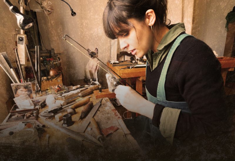 A woman sits in a workshop crafting a violin bow from scratch