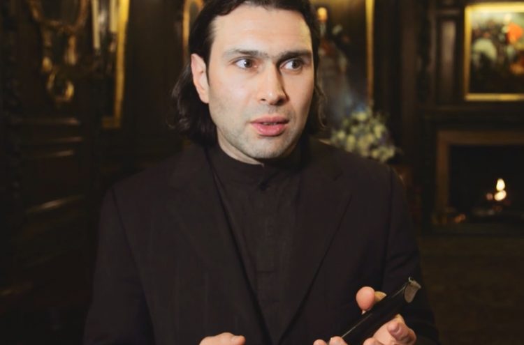 Conductor Vladmir Jurowski poses dressed in an all black suit looking to the right of the camera
