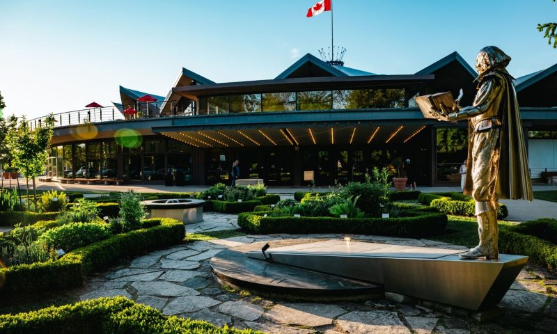 View of the outside of the Stratford Festival theatre main building with a statue of William Shakespeare in the foreground
